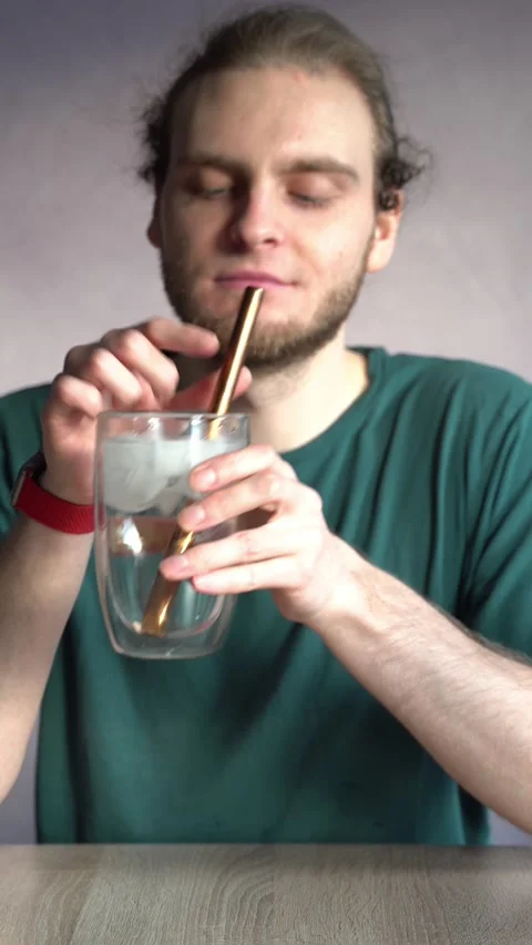 Young man drinking ice water, smiling and vibing to music Stock Footage 229651248