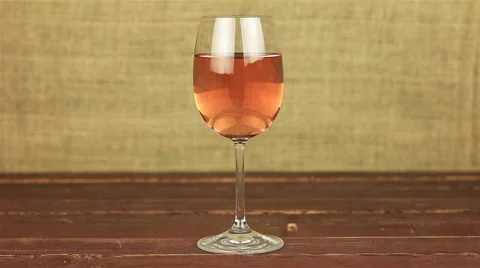 Young man drinking rose wine on wooden table Stock Footage 66235669