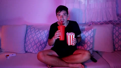 Young man drinking soda while watching a movie at home Video stock 289731664