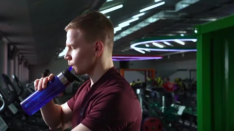 Young man drinking water from a bottle during cardio workout. Stock Footage 102709369