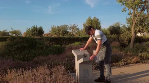Young man drinking water from the drinking fountain Stock Footage 133093690