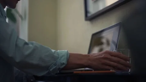 Young man drinking water using laptop at home. Browser page on laptop screen. Stock Footage 82925208