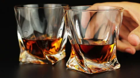 Young man drinking whiskey over black background Stock Footage 66242621