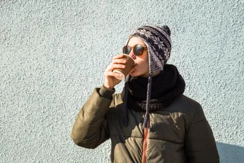 Young man drinks coffee to go from paper cup. Handsome teenage male person in Stock Photos