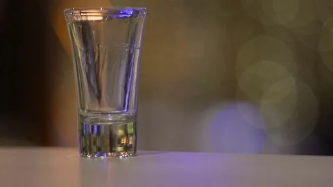 Young man drinks down strong shot of alcohol. Vídeos de archivo 74177400