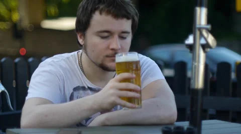 Young Man Drinks In Pensive Thought Video stock 39679650
