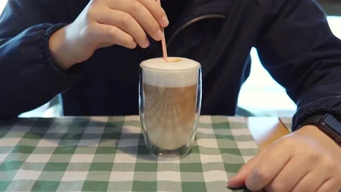 A young man drinks pumpkin cappuccino in a coffee shop. Coffee is made barista Stock Footage 160573377