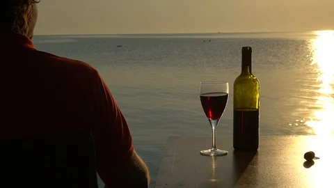 Young man Drinks Red Wine From A Glass, Sunset By The Sea 動画素材 96475772