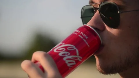 Young Man drinks Soda Cola, opens a metal Jar - evening in City Urban Landscape Stock Footage 78960837