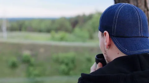 A young man drinks tea from a thermos in the forest area Stock Footage 90339887