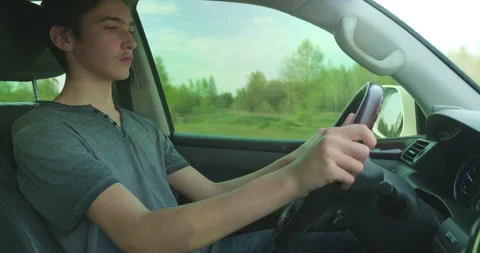 Young man drives the car at first time.  Novice driver is driving a car. Teen 스톡 동영상 141706067
