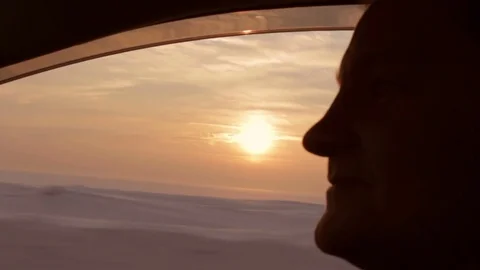 Young man drives a car under sunset wears sunglasses. Close up profile shot Stock Footage 74434340