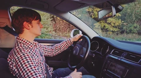 Young Man Driving a Car, 4K. Sunny Autumn Morning or Evening, Lens Flare. 库存影片 67223848
