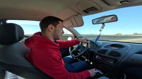 Young man driving a car Stock Footage 233427548