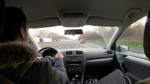 Young man driving a car, view from back seat through windshield Stock Footage 103573135