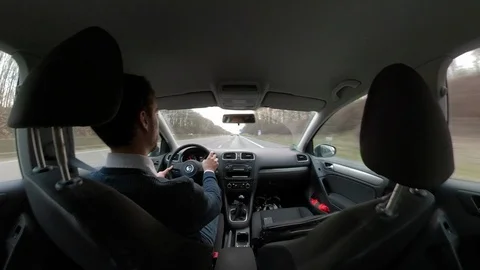 Young man driving a car, view from back seat through windshield Stock Footage 103575185