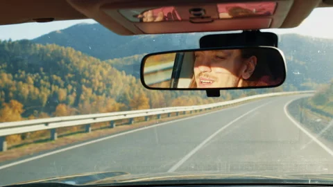 Young man driving reflected in rearview mirror Stock-Footage 312275661