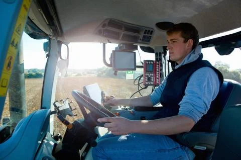 Young man driving tractor using global positioning system Stock Photos