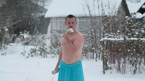 Young man with dumbbells making exercise training on snowy weather Video stock 255022356