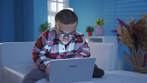 Young man with dwarfism doing focused and serious work at home  Stock Footage 230973954