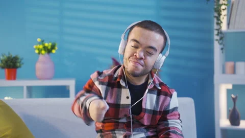Young man with dwarfism listening to pleasant and entertaining music feels happy 動画素材 230972764