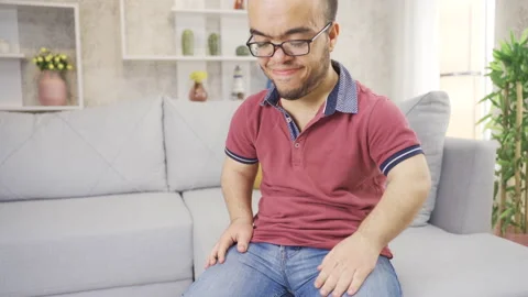 The young man with dwarfism is thinking at home, and what comes  Stock Footage 230967184