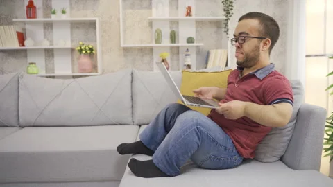 Young man with dwarfism working online from laptop at home Stock Footage 230967279