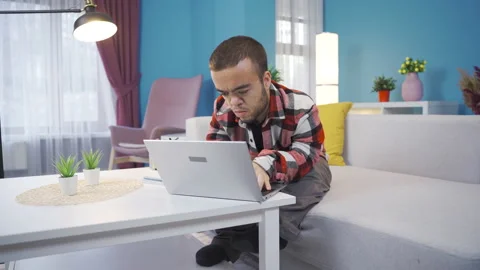 Young man with dwarfism works remotely from home with laptop  Stock Footage 230975752