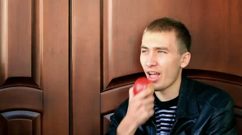 Young man eating apple. Видео 12046326