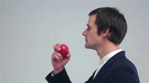 Young man eating an apple Stockbeeldmateriaal 68997295