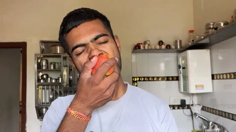 Young Man Eating an Apple in the Kitchen Video stock 321388458
