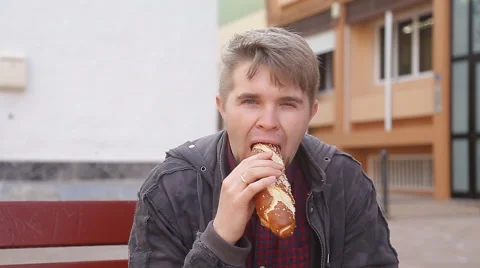 Young man eating a bread Vidéo 48687639