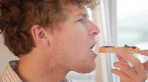 Young man eating bread with nutella Stock Footage 41277749