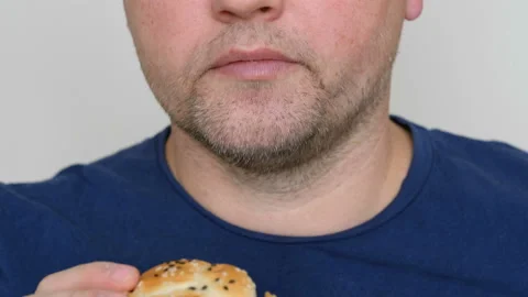 Young man eating a burger . Fast food concept. Close up Stockbeeldmateriaal 102334610