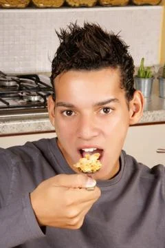 Young man eating cornflakes Stock Photos