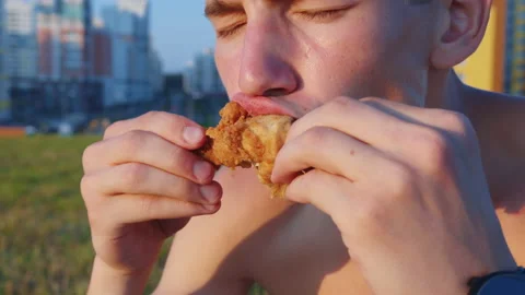 Young man eating fat fried chicken Stock Footage
