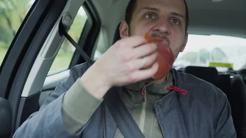 The young man is eating jerky meat in the car Stock Footage 85459786