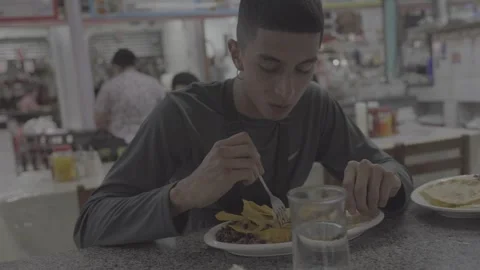 A young man is eating at a restaurant in San José, Costa Rica Stock-Footage 344339587