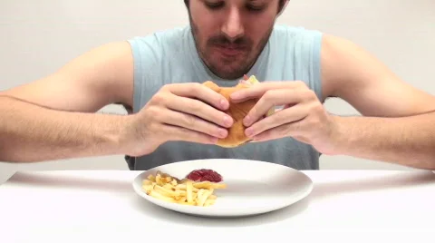 Young man eats burger and fries in fast motion - HD  Stock Footage 500895