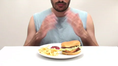 Young man eats burger and fries - HD  Stock Footage 500905