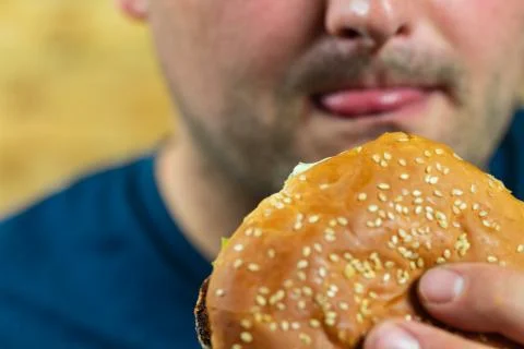 Young man eats delicious appetizing burger. Foto stock