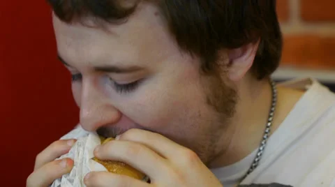 Young Man Eats Double Cheeseburger Stock Footage 39840309