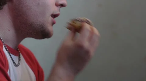 Young Man Eats Doughnut And Licks Fingers Video stock 41553722