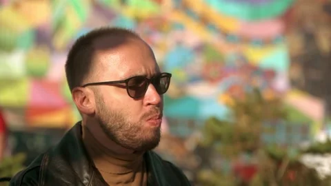 Young man eats a hot dog outdoor in cafe Stock Footage 161084453
