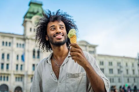 A young man eats ice cream while enjoying his holidays in Trieste Stock Photos