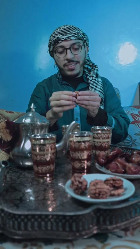 A young man eats nuts alone in an Arab atmosphere during Eid. Video stock 303967443