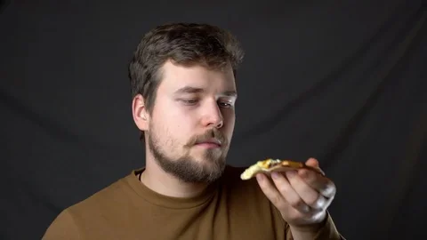 A young man eats pizza with cheese on the top Stock-Footage 124515144