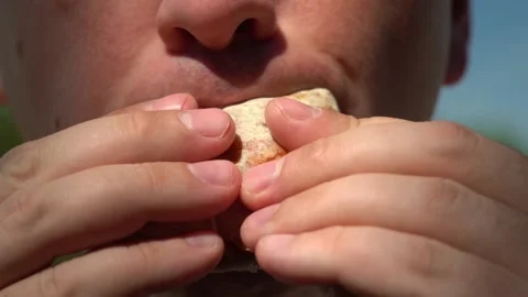A young man eats shawarma on a background of forest and blue sky Stock Footage 156046703