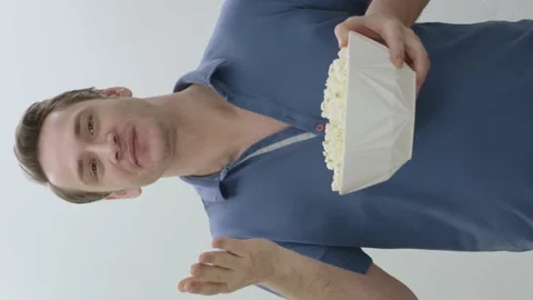 A young man eats spicy chips or popcorn.Snack junk food concept. Stock Footage 201016986