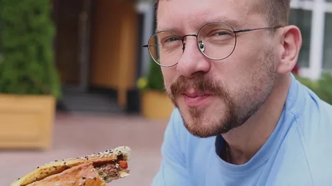 A young man eats street food Stock Footage 335320623